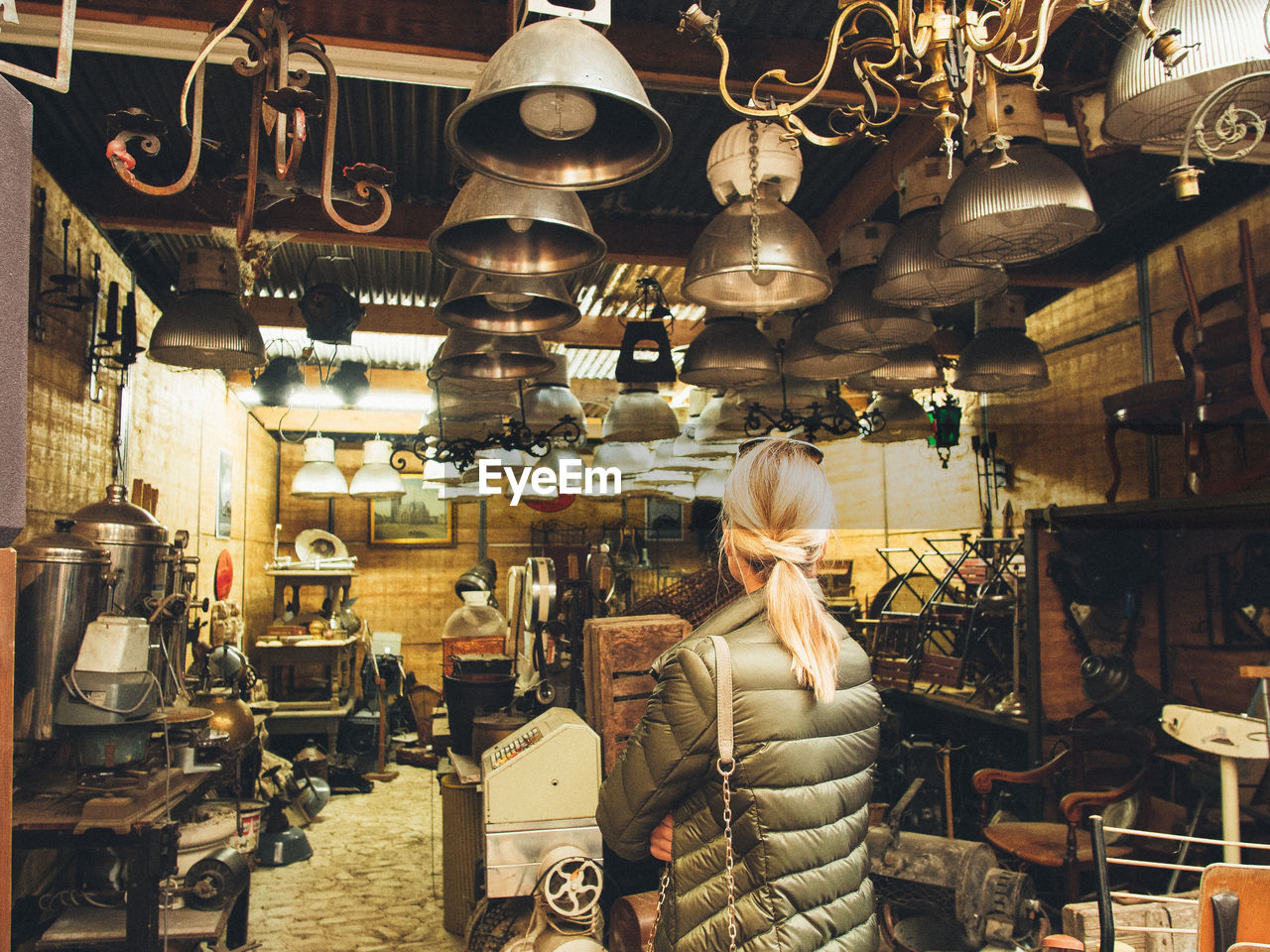 WOMAN STANDING BY ILLUMINATED STORE