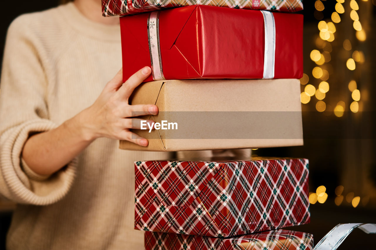 Woman holds pile og presents in gift box