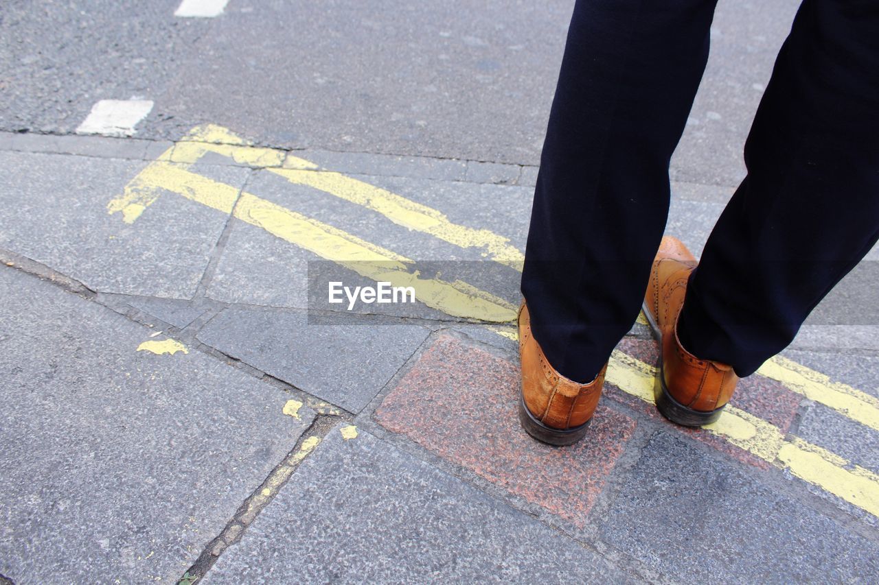 Low section of man standing on road