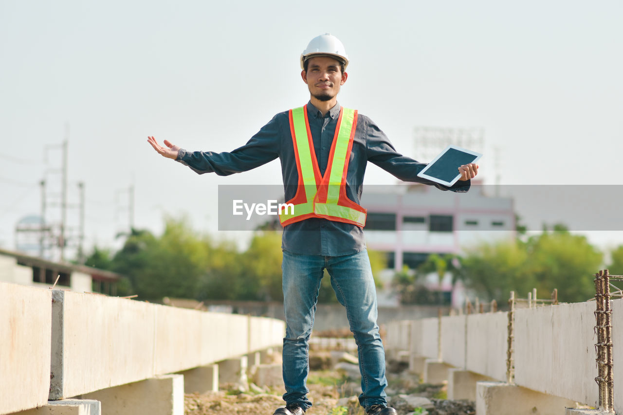 PORTRAIT OF YOUNG MAN STANDING OUTDOORS