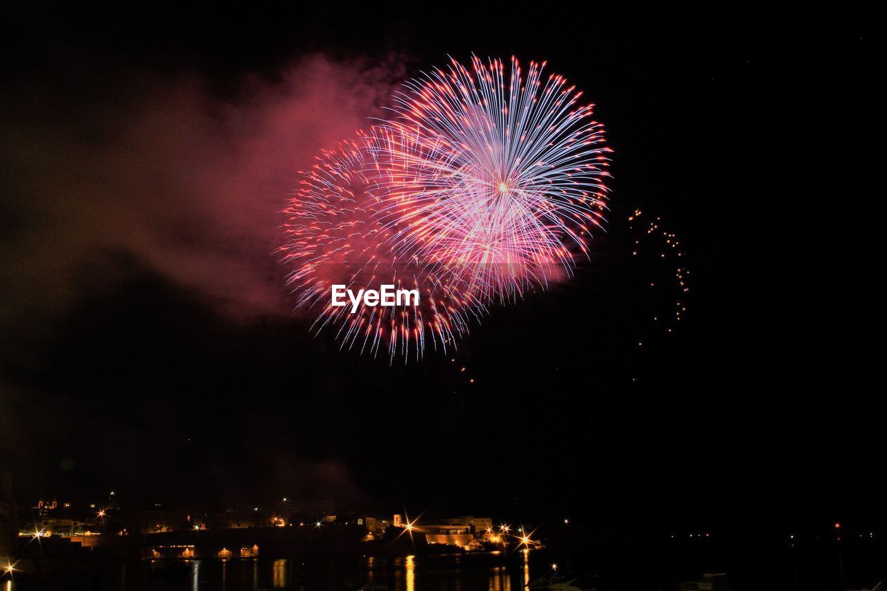 Low angle view of firework display at night