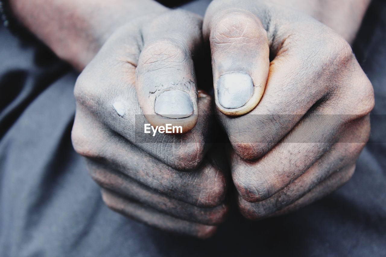 Cropped image of person showing dirty hands