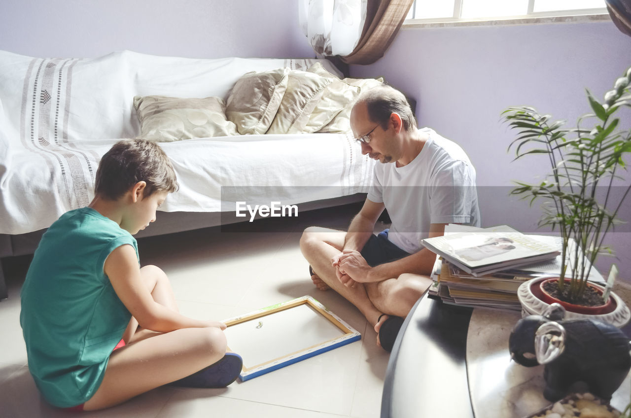 Father and child son playing glazing balls at home. happy home concept. salvador, bahia, brazil.