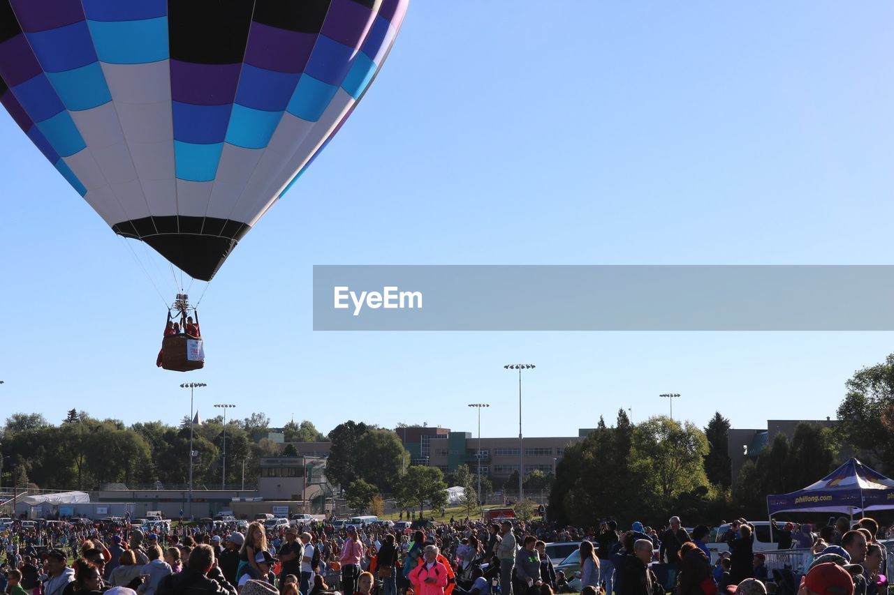 PEOPLE ON HOT AIR BALLOONS AGAINST CLEAR SKY