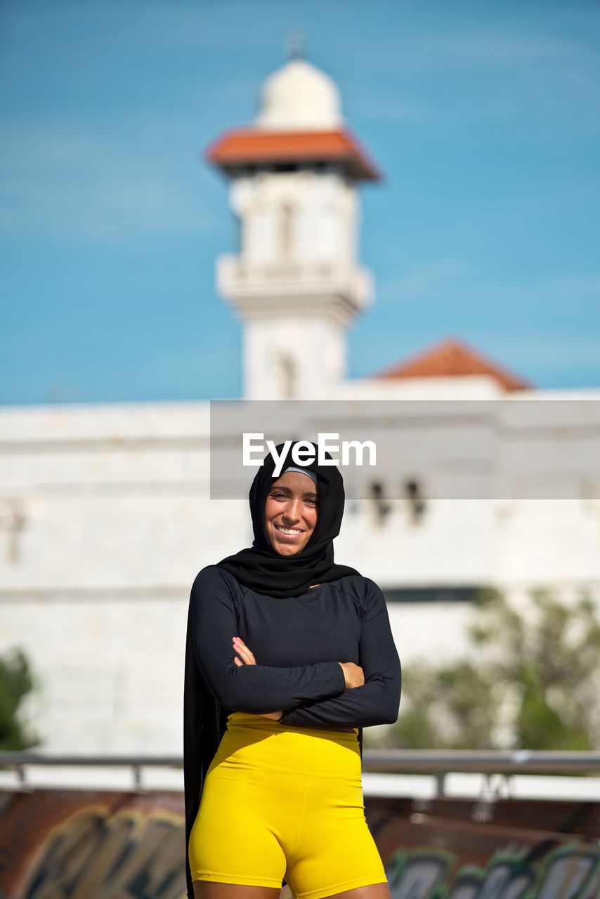 Portrait of woman in hijab standing against building