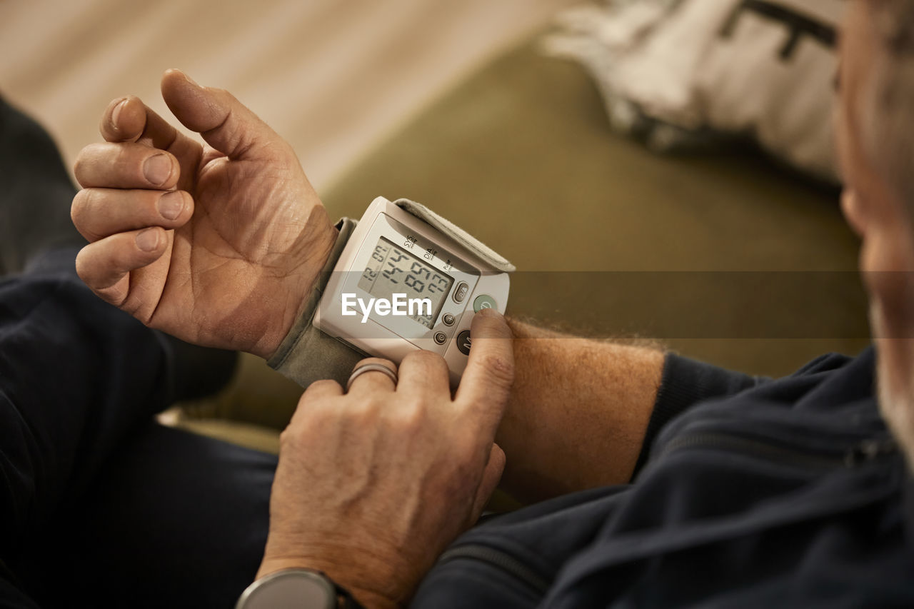 Senior man checking blood pressure at home