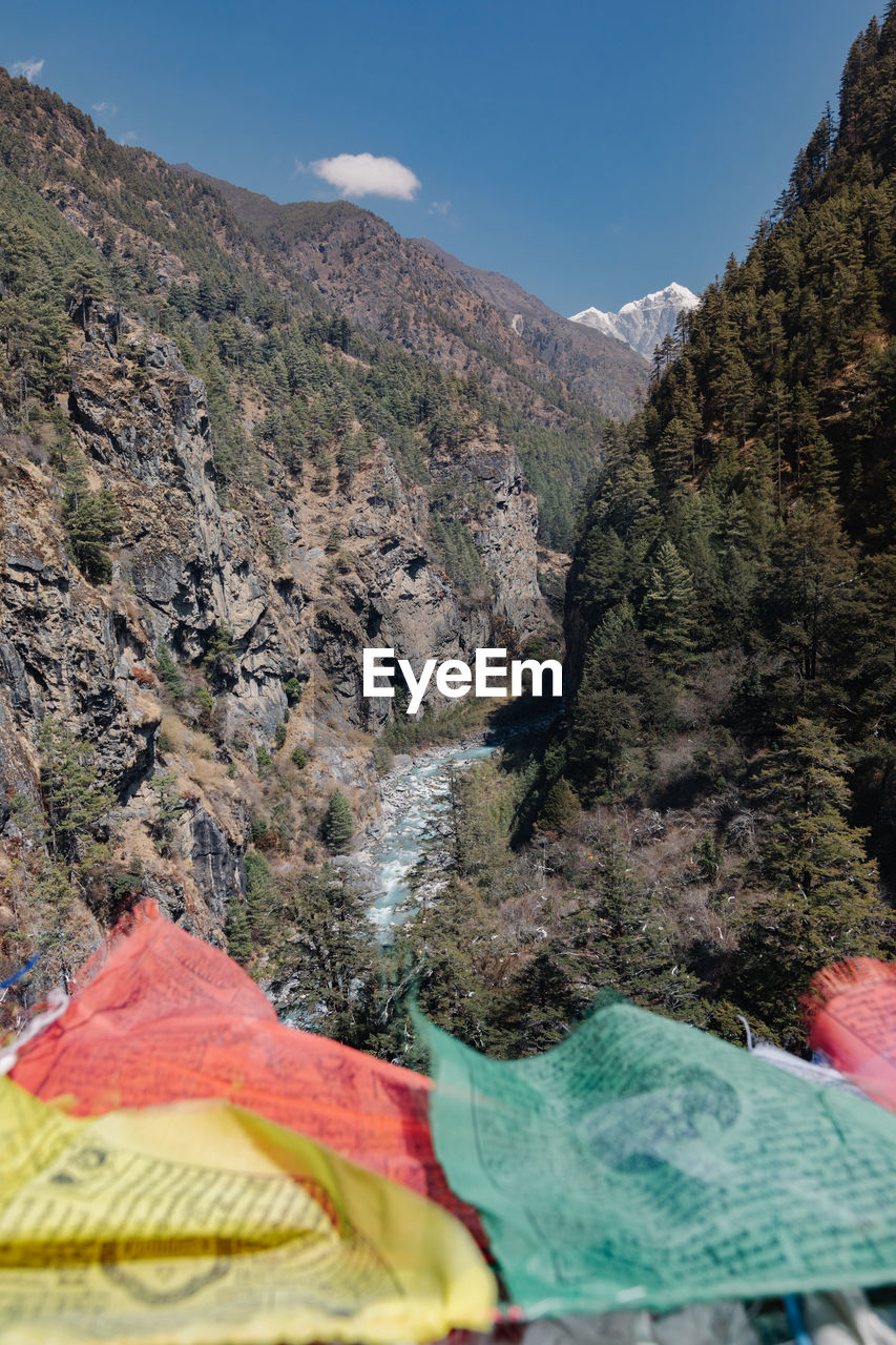 SCENIC VIEW OF WATERFALL AGAINST MOUNTAIN