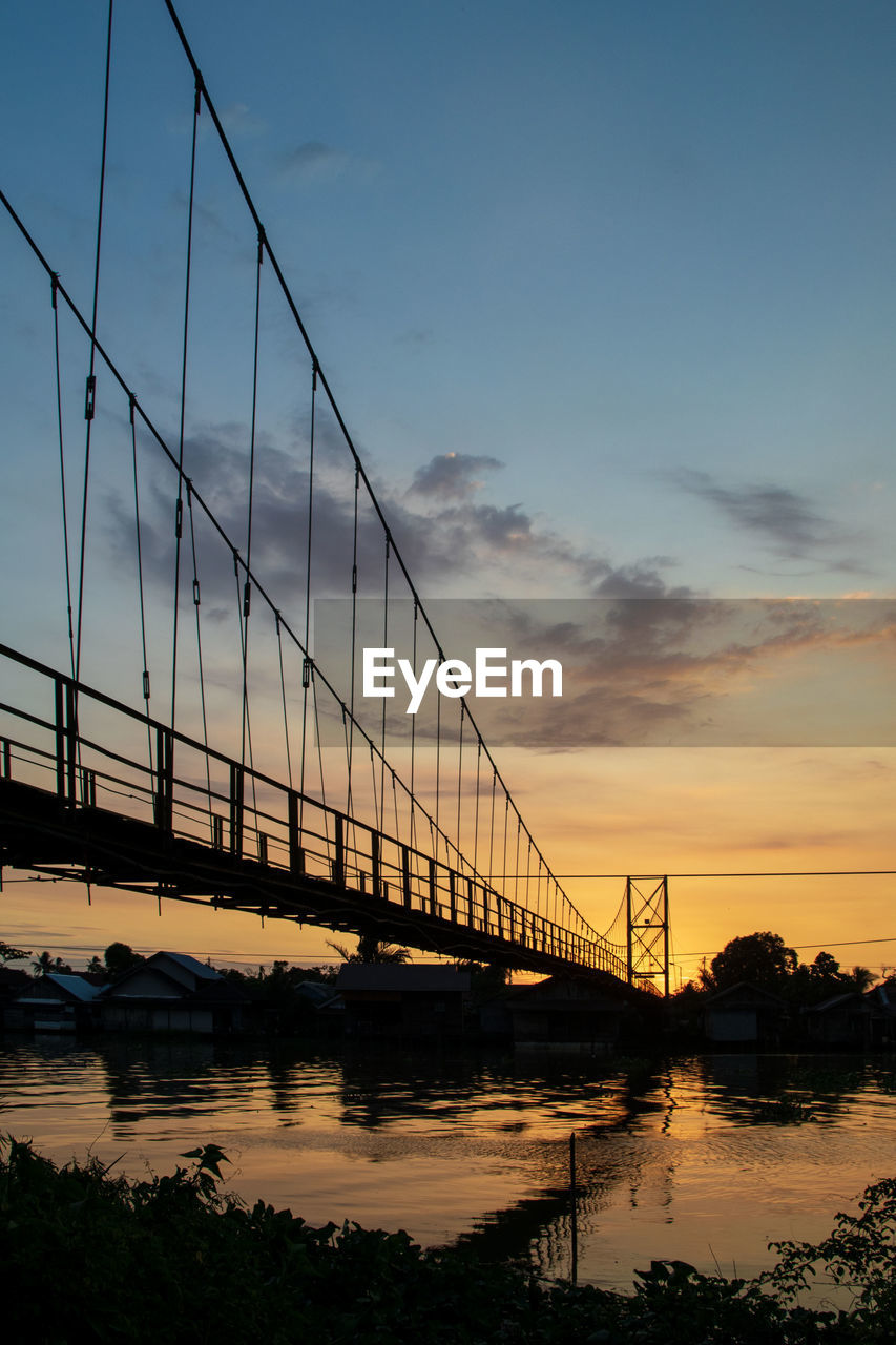 sky, bridge, water, architecture, built structure, transportation, sunset, nature, suspension bridge, travel destinations, reflection, cloud, city, engineering, sea, dusk, travel, tourism, cable-stayed bridge, beauty in nature, evening, scenics - nature, landscape, building exterior, dramatic sky, outdoors, bay, tranquility, cityscape, bay of water, silhouette, environment, twilight, mode of transportation, nautical vessel, tranquil scene, building, horizon, beach, sunlight, urban skyline