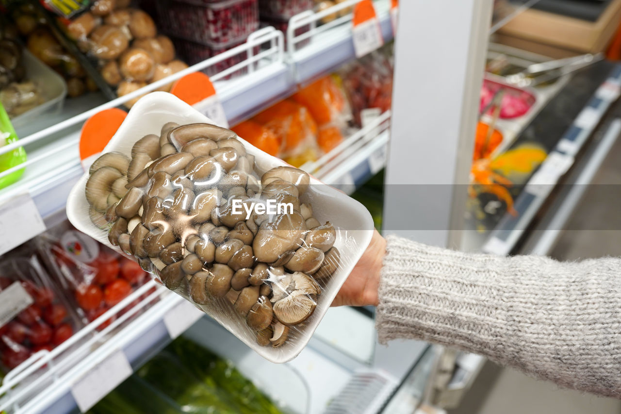 Mushrooms in female hand in the store, healthy vegan food