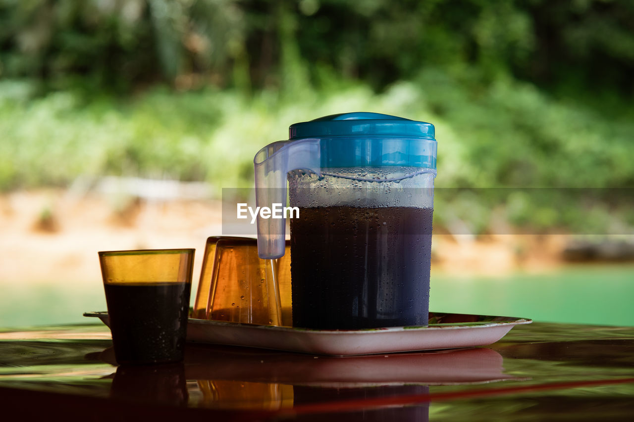 CLOSE-UP OF DRINK ON TABLE AGAINST BLURRED BACKGROUND