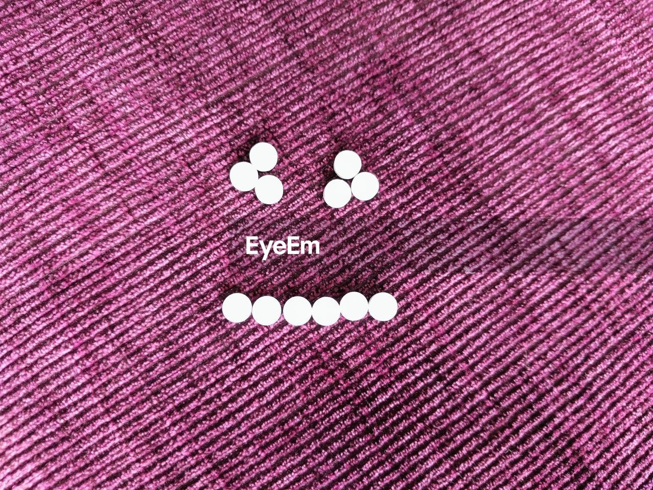 Close-up of pills arranged in face