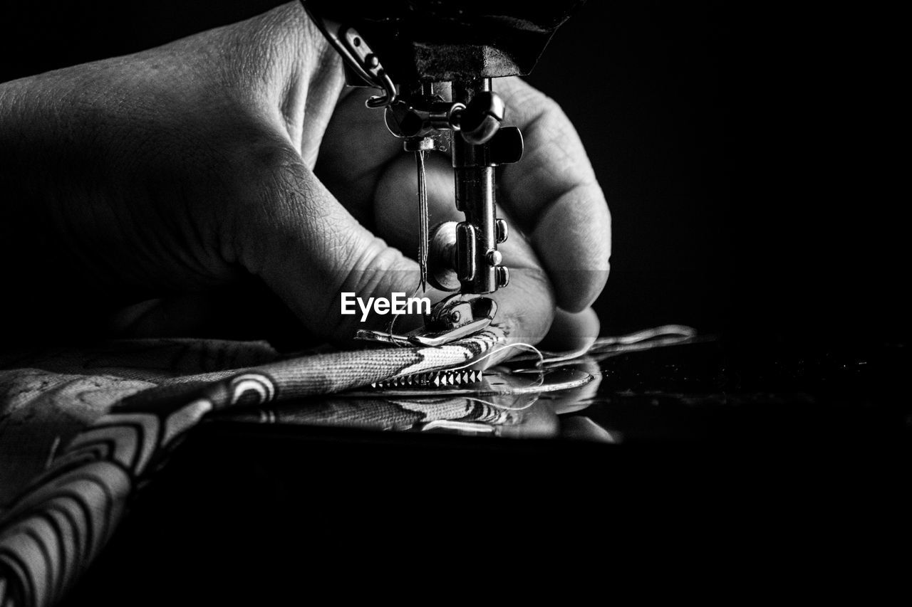 Close-up of person using sewing machine