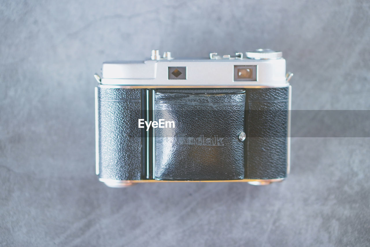 CLOSE-UP OF VINTAGE CAMERA ON TABLE