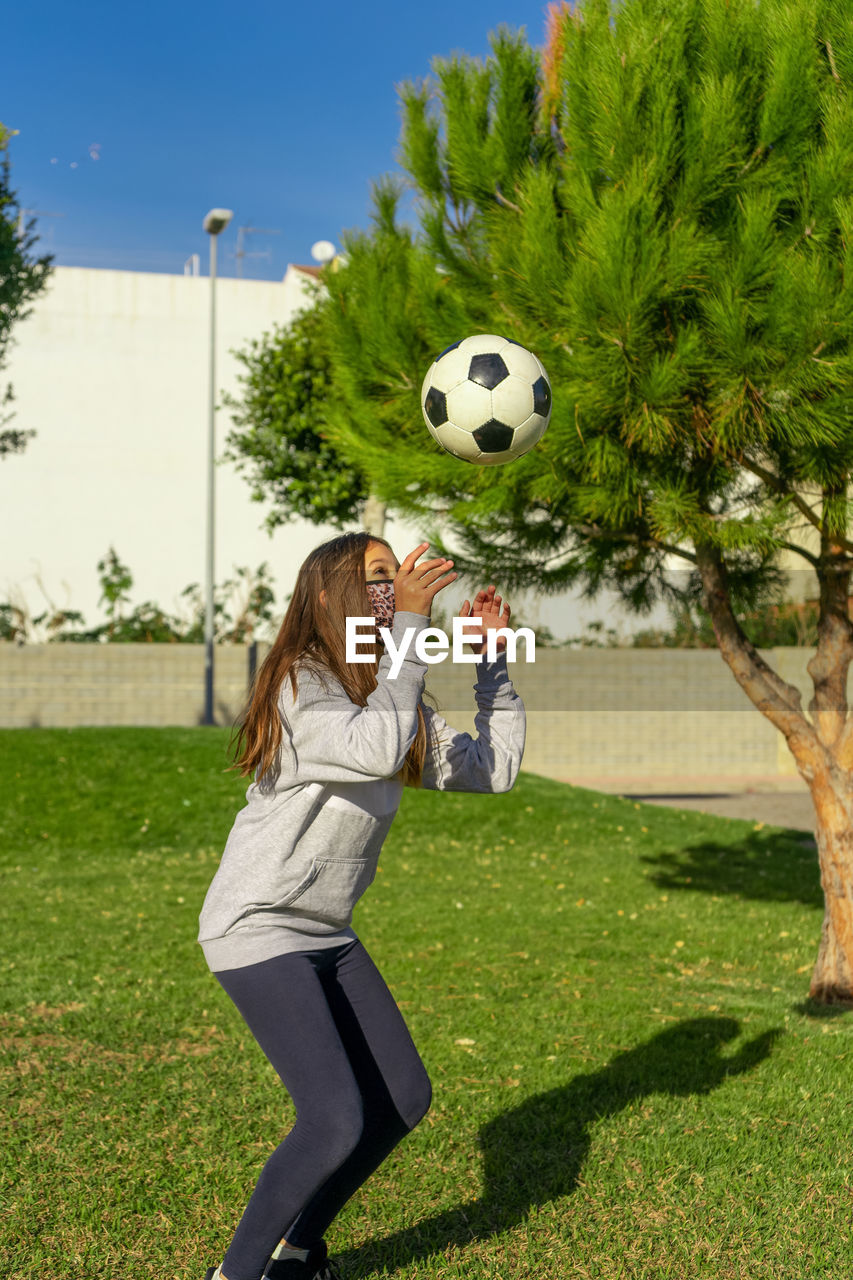 Full length of girl playing soccer on field