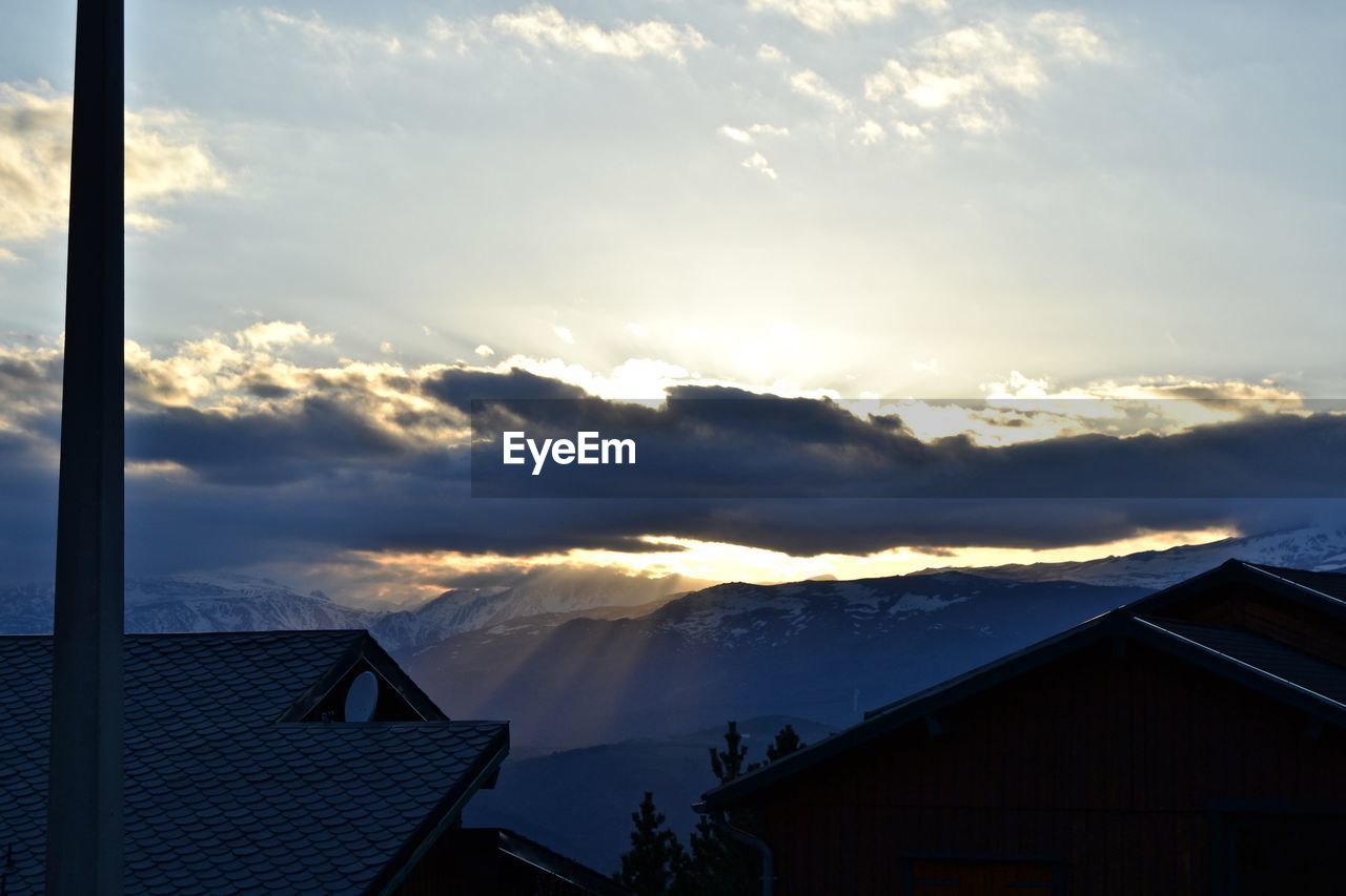 Houses and buildings against sky during sunset