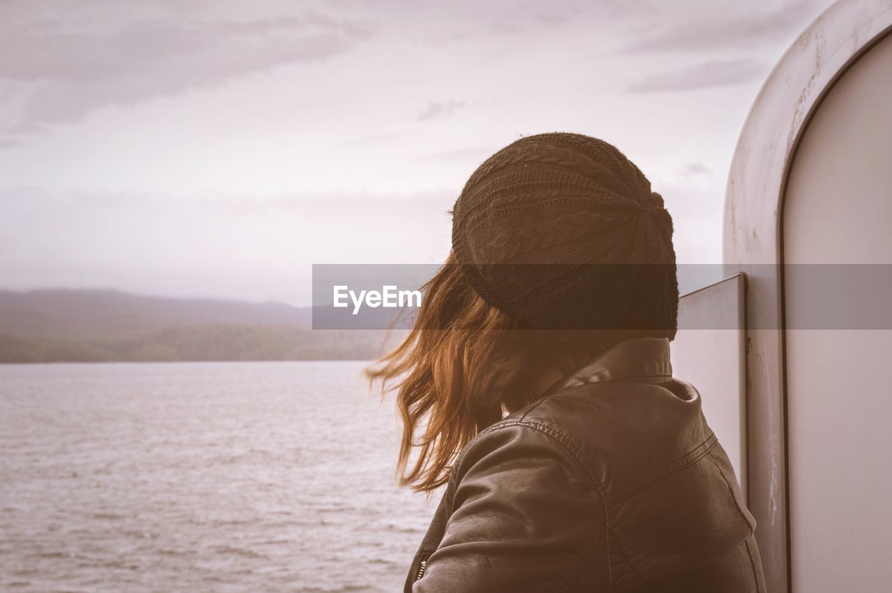 Rear view of woman looking at sea against sky