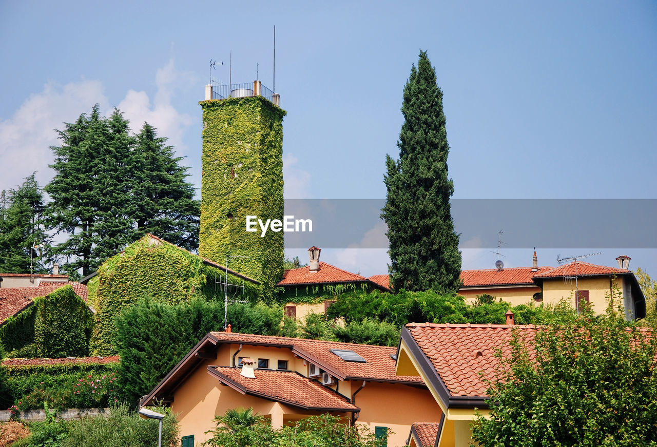 Houses and trees against sky