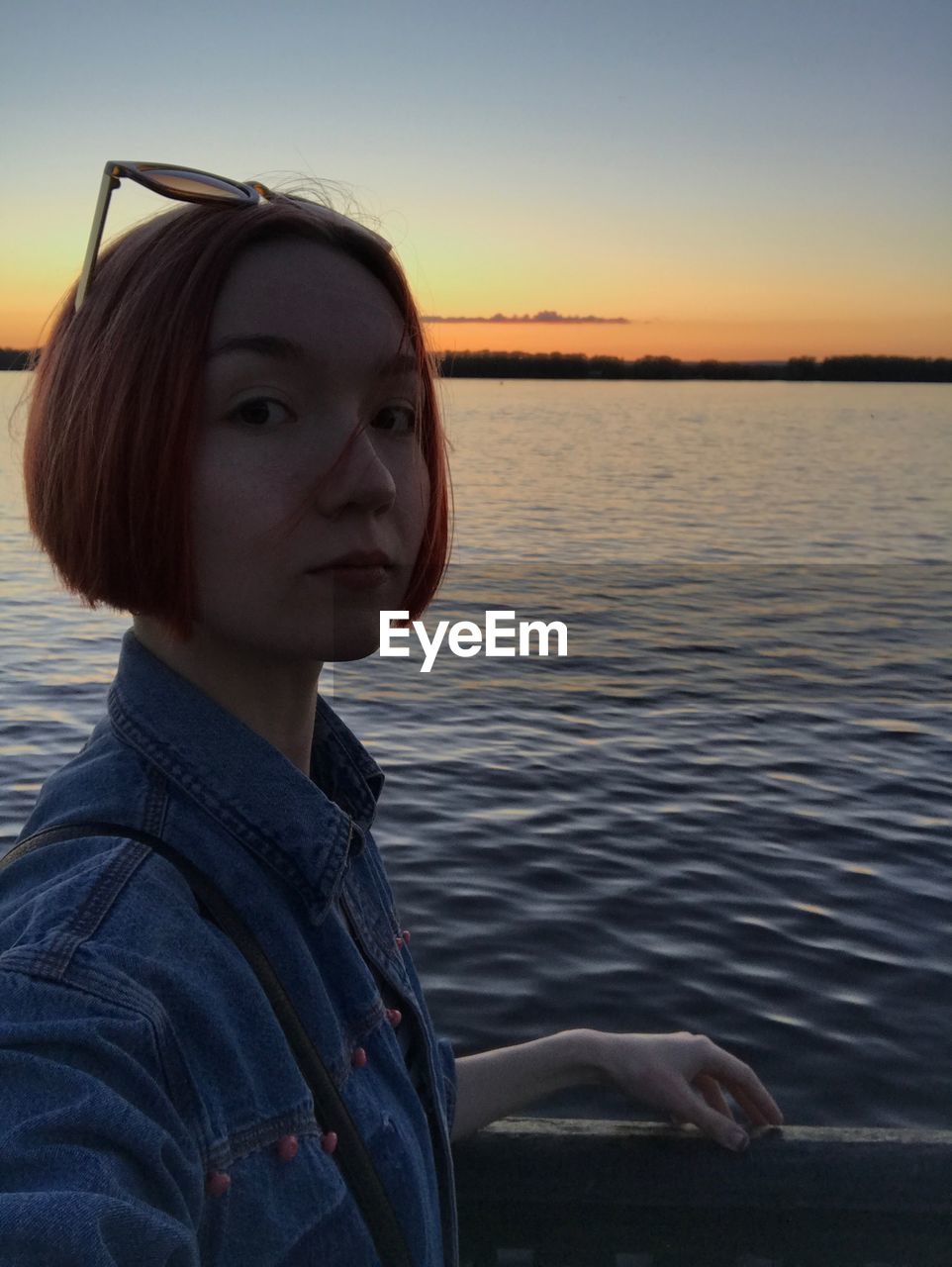 PORTRAIT OF YOUNG WOMAN AGAINST LAKE AGAINST SKY