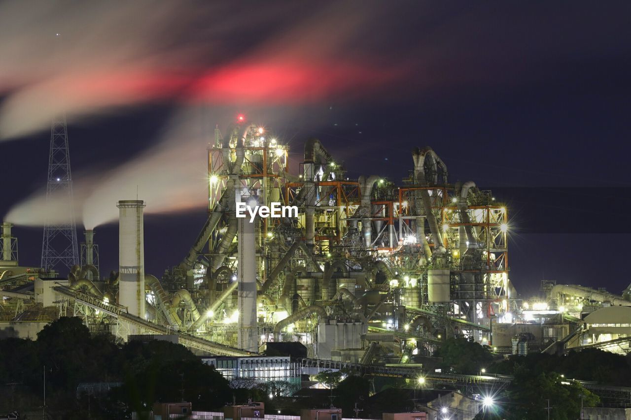 Illuminated cityscape against sky at night