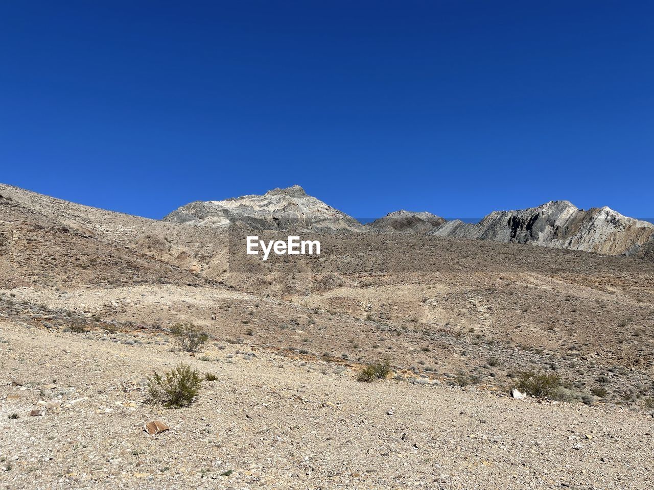 Scenic view of mountains against clear blue sky