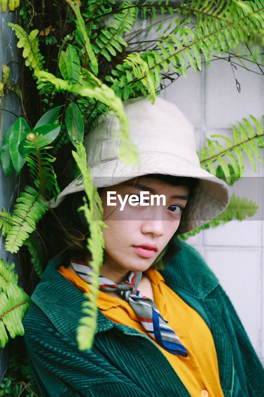 green, one person, portrait, child, childhood, clothing, headshot, hat, plant, looking at camera, leaf, flower, men, plant part, yellow, nature, day, outdoors, person, looking, jungle, costume, sun hat, front view, growth, lifestyles, human face, serious, leisure activity, innocence, fashion accessory, standing