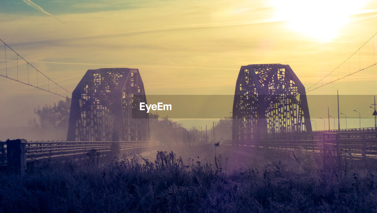 View of bridge against cloudy sky during sunset