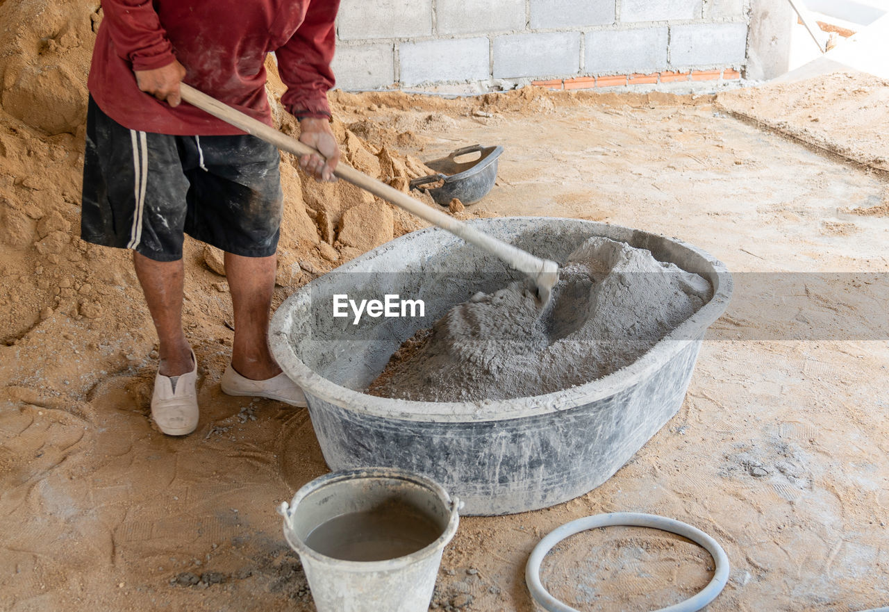 low section of man working on pottery wheel