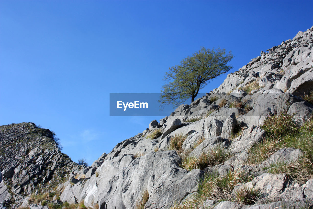 LOW ANGLE VIEW OF MOUNTAIN AGAINST BLUE SKY