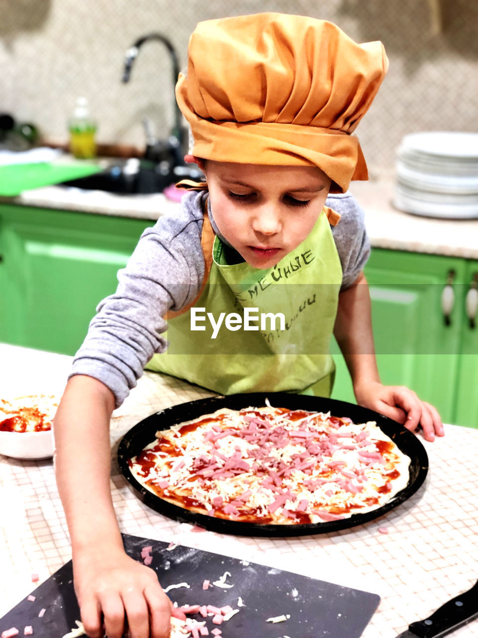Boy preparing pizza at home