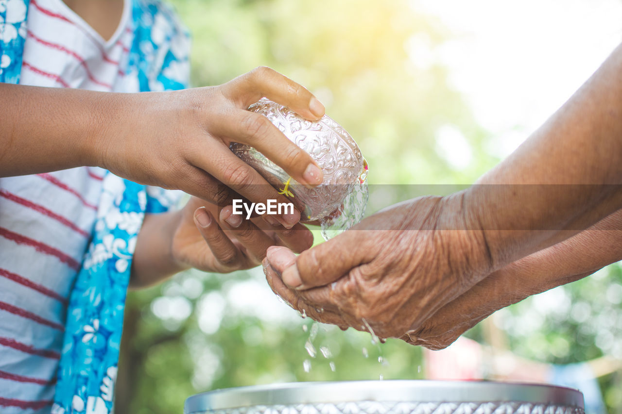 Midsection of girl pouring water on hands