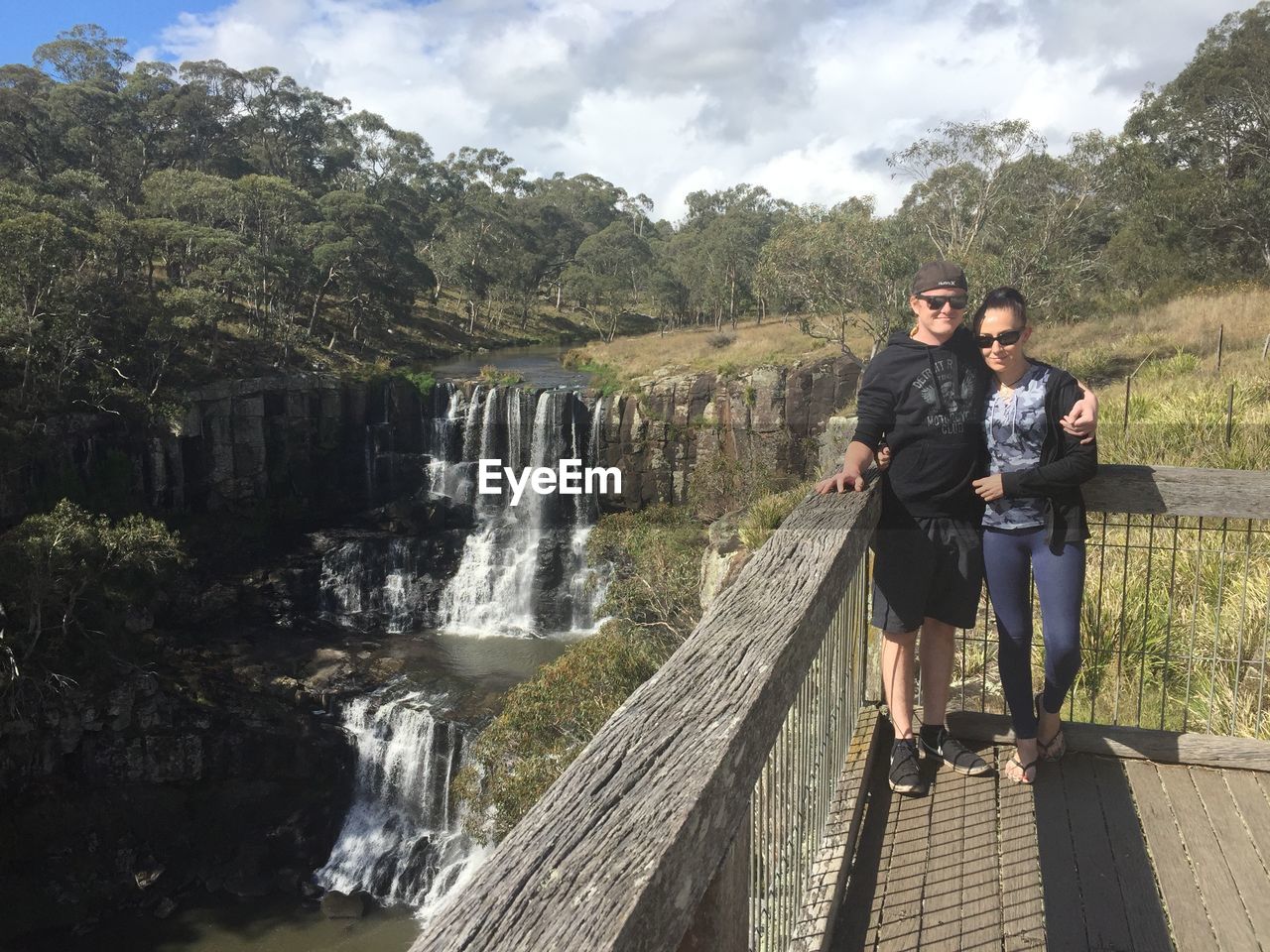 Couple standing by waterfall against plants