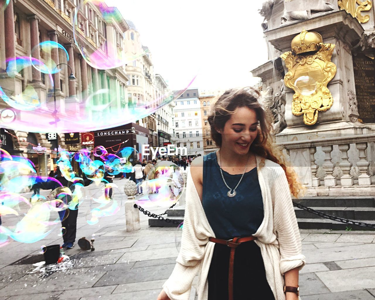 Woman standing by bubbles on street