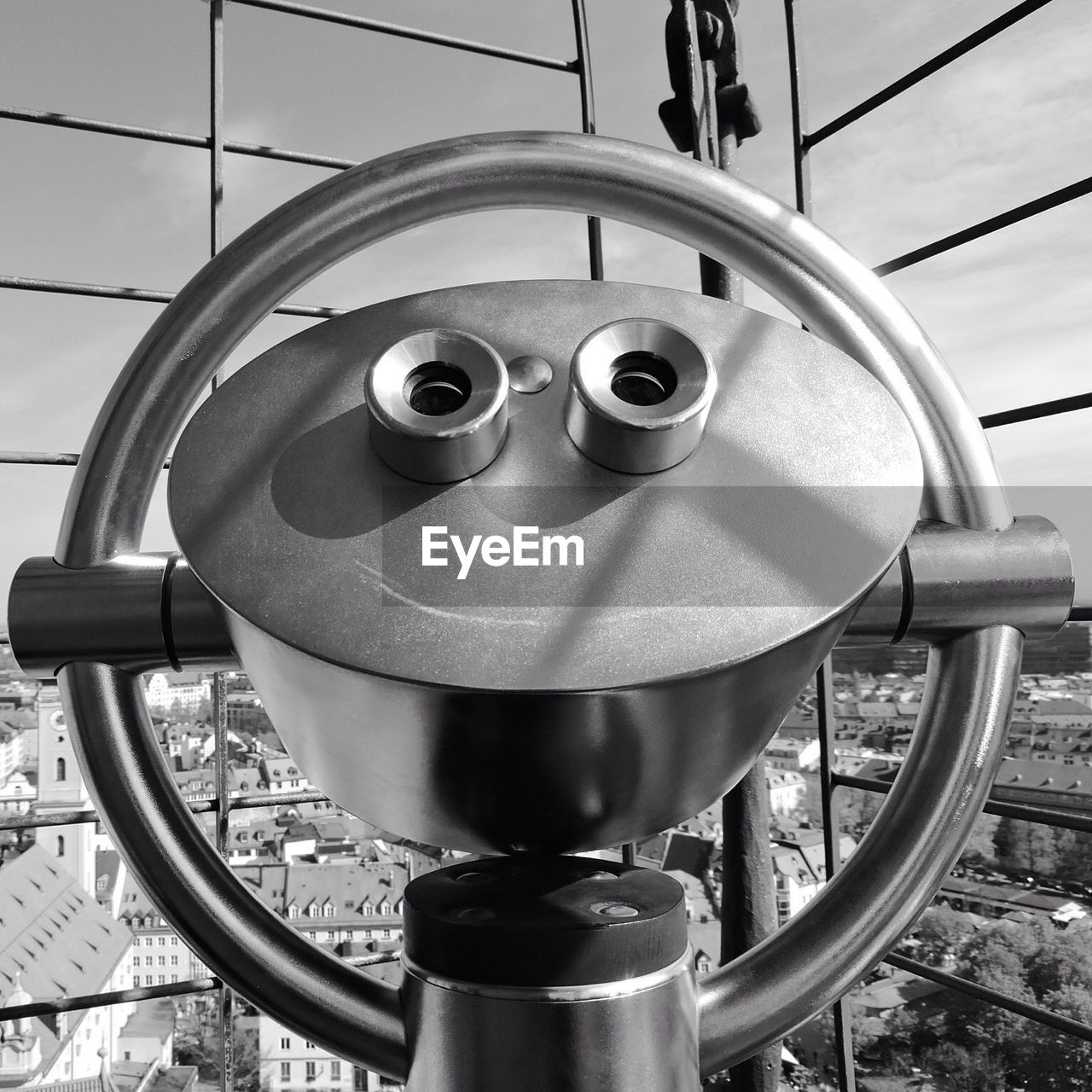 Close-up of coin operated binoculars facing cityscape