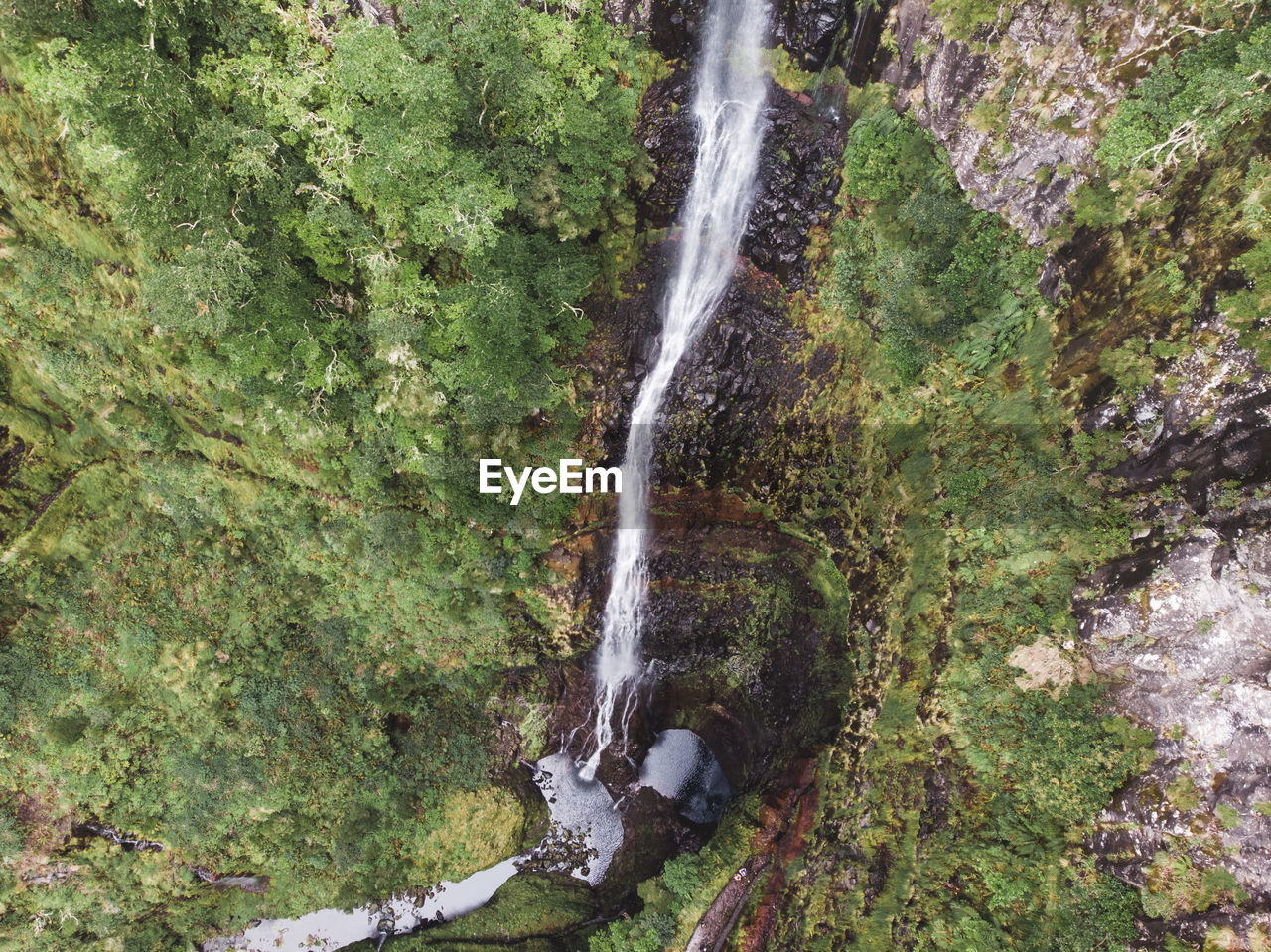 Scenic aerial  view of waterfall in forest from above