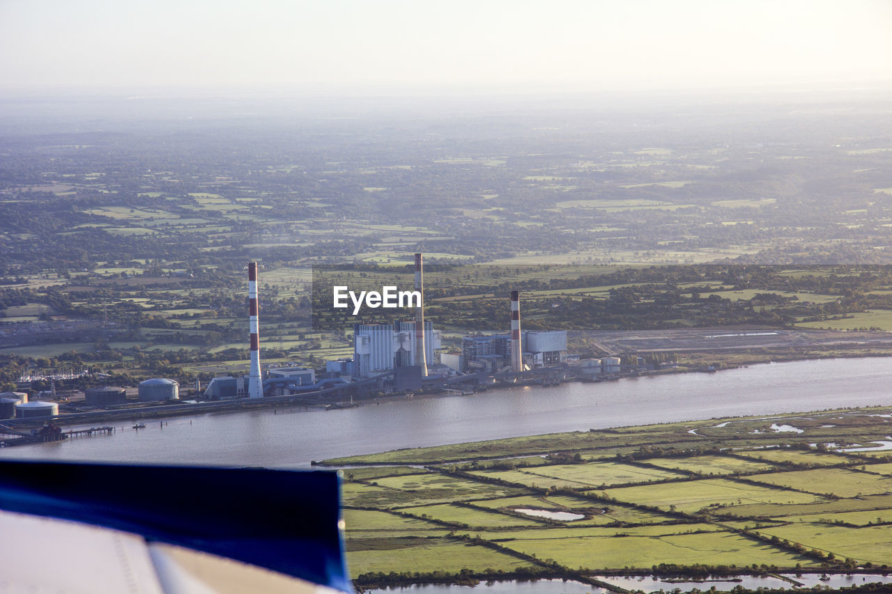 AERIAL VIEW OF RIVER AMIDST CITYSCAPE AGAINST SKY