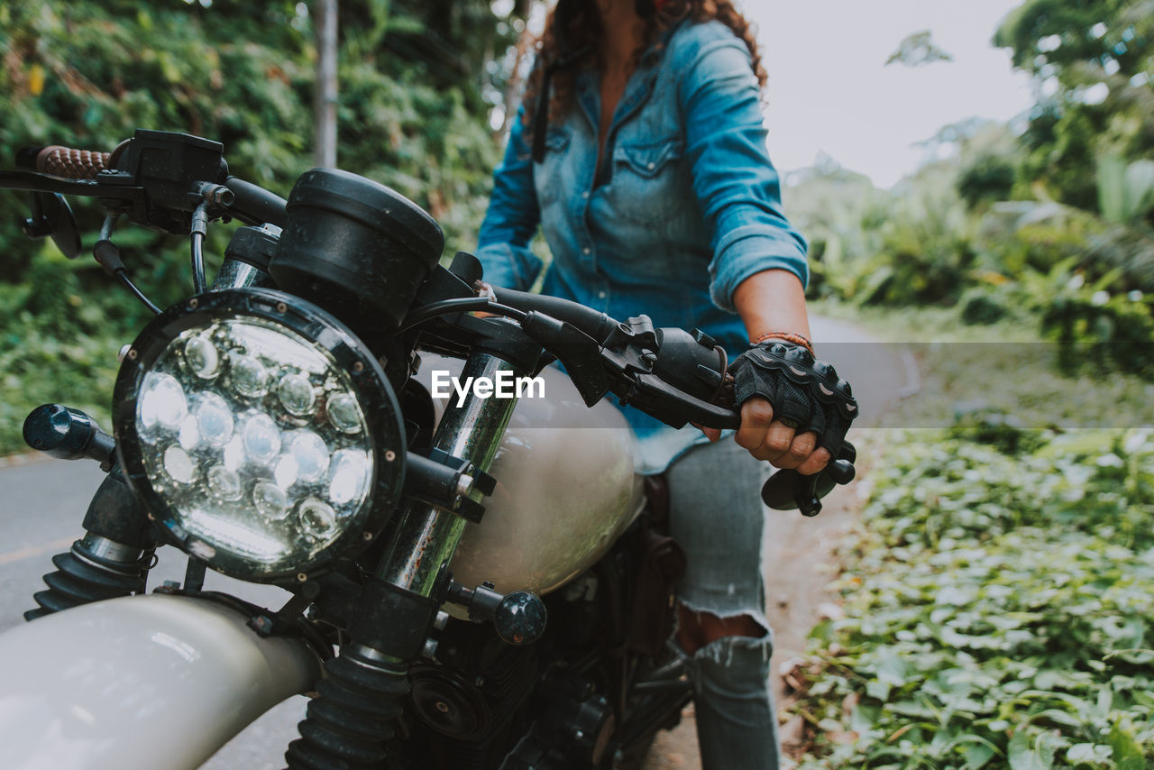 Midsection of woman sitting on motorcycle