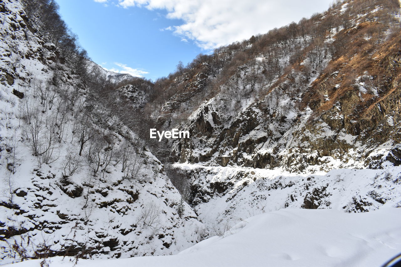 SNOW COVERED LANDSCAPE AGAINST SKY