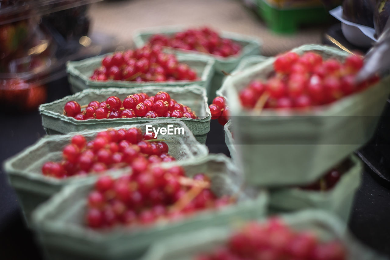 Close-up of red currents in containers at market