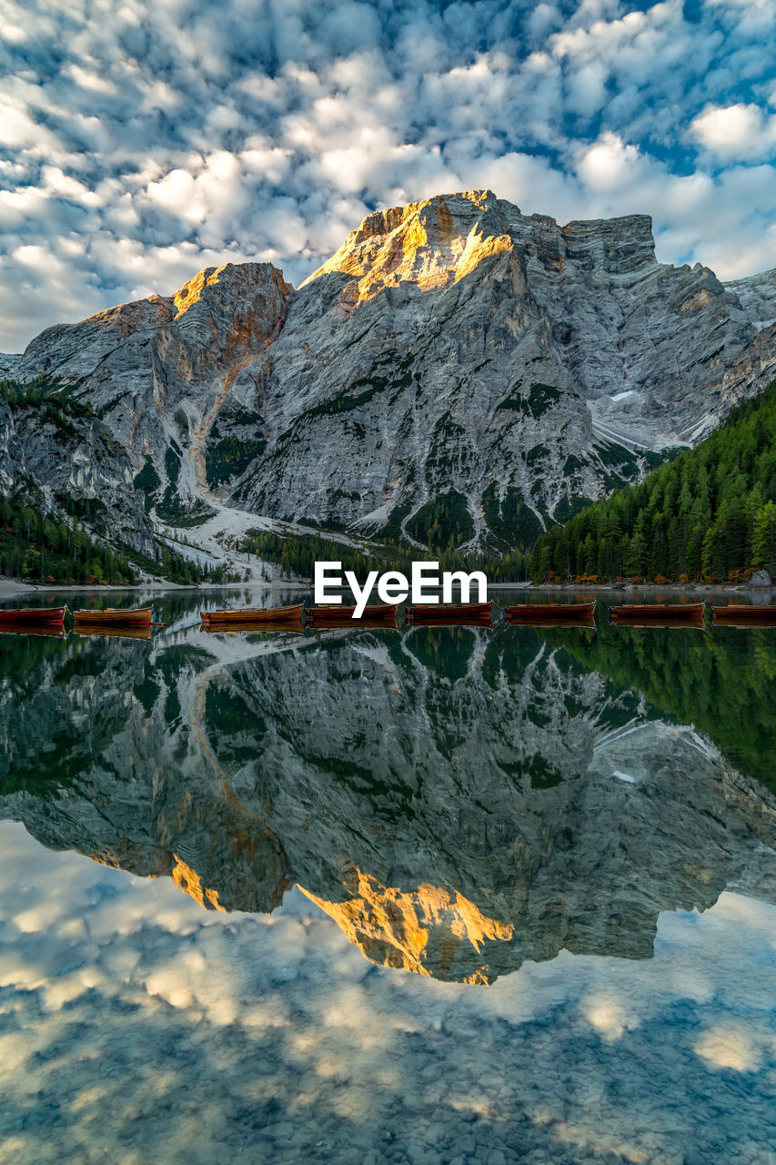 Scenic view of lake by snowcapped mountains against sky