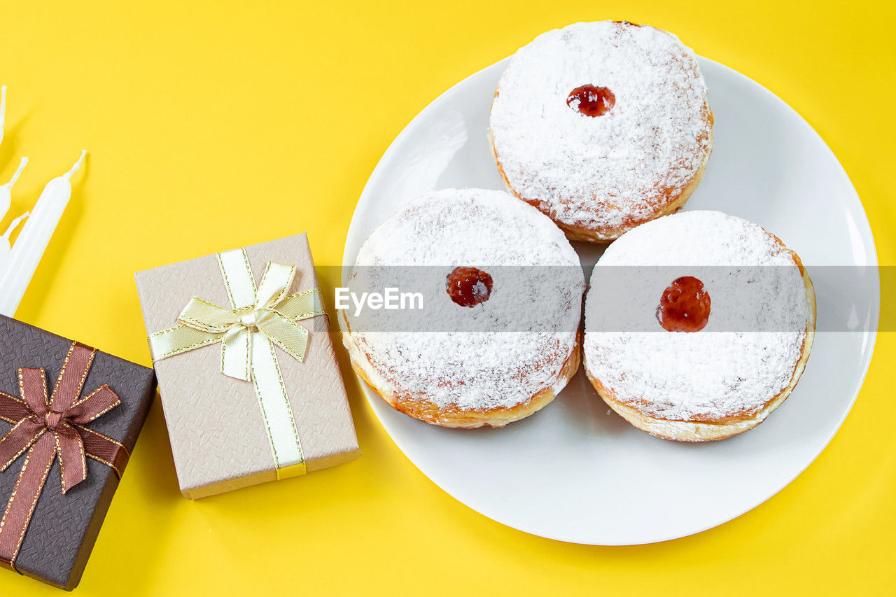 food, food and drink, sweet food, sweet, celebration, dessert, no people, icing, baked, studio shot, holiday, yellow, plate, still life, cake, ribbon, colored background, indoors, event, high angle view, decoration, bow, gift, tied bow, party favor, shape, paper, christmas, produce