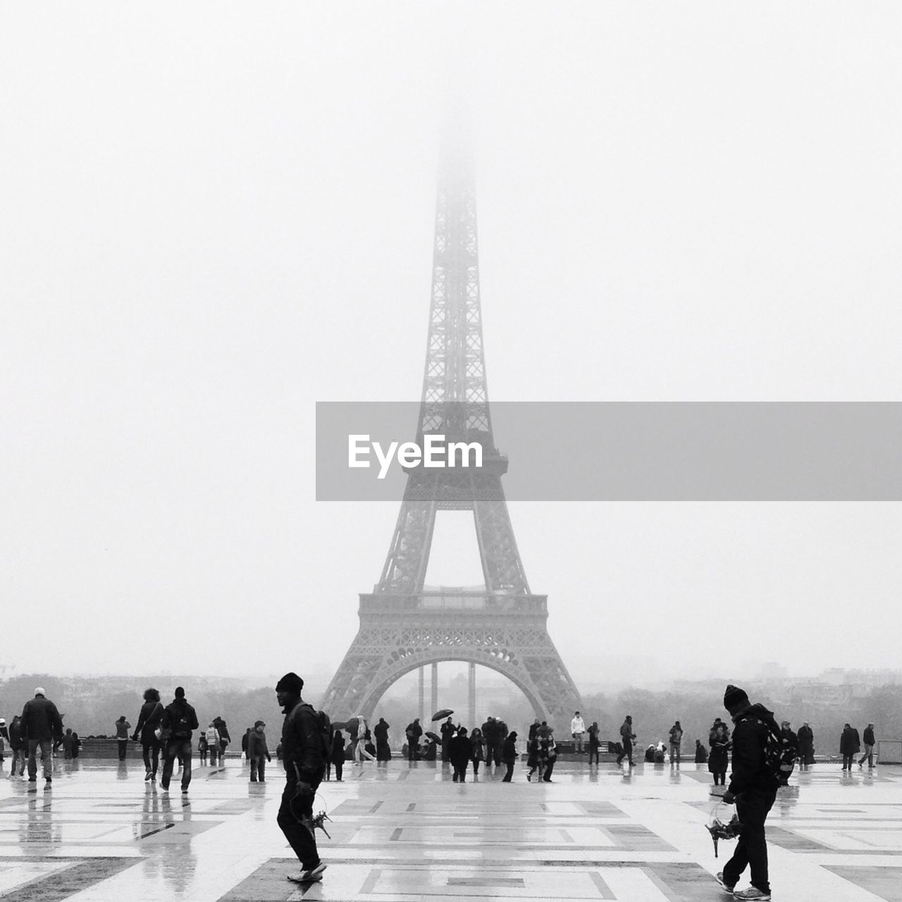 Tourists at eiffel tower in foggy weather