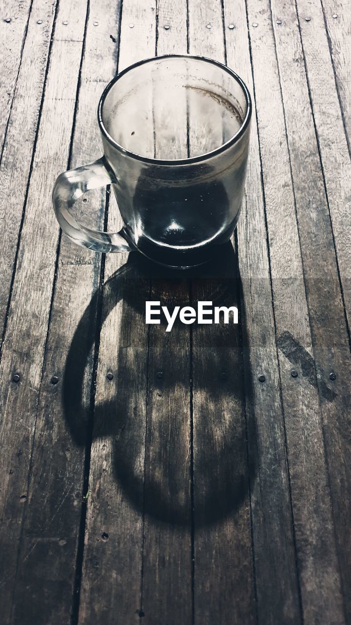 Sebuah gelas kopi kosong dalam bayangan gelap