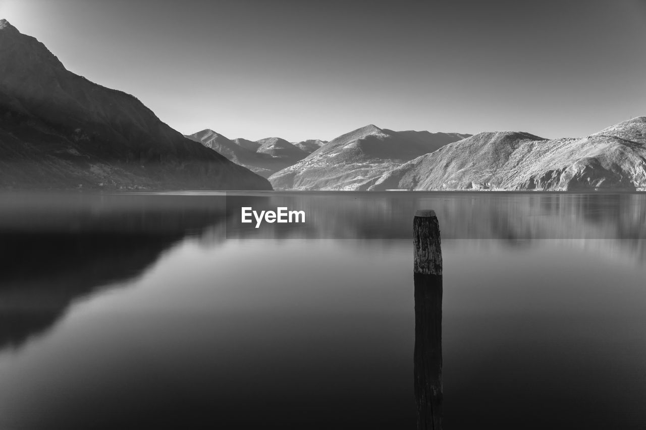 Scenic view of lake by mountains against clear sky