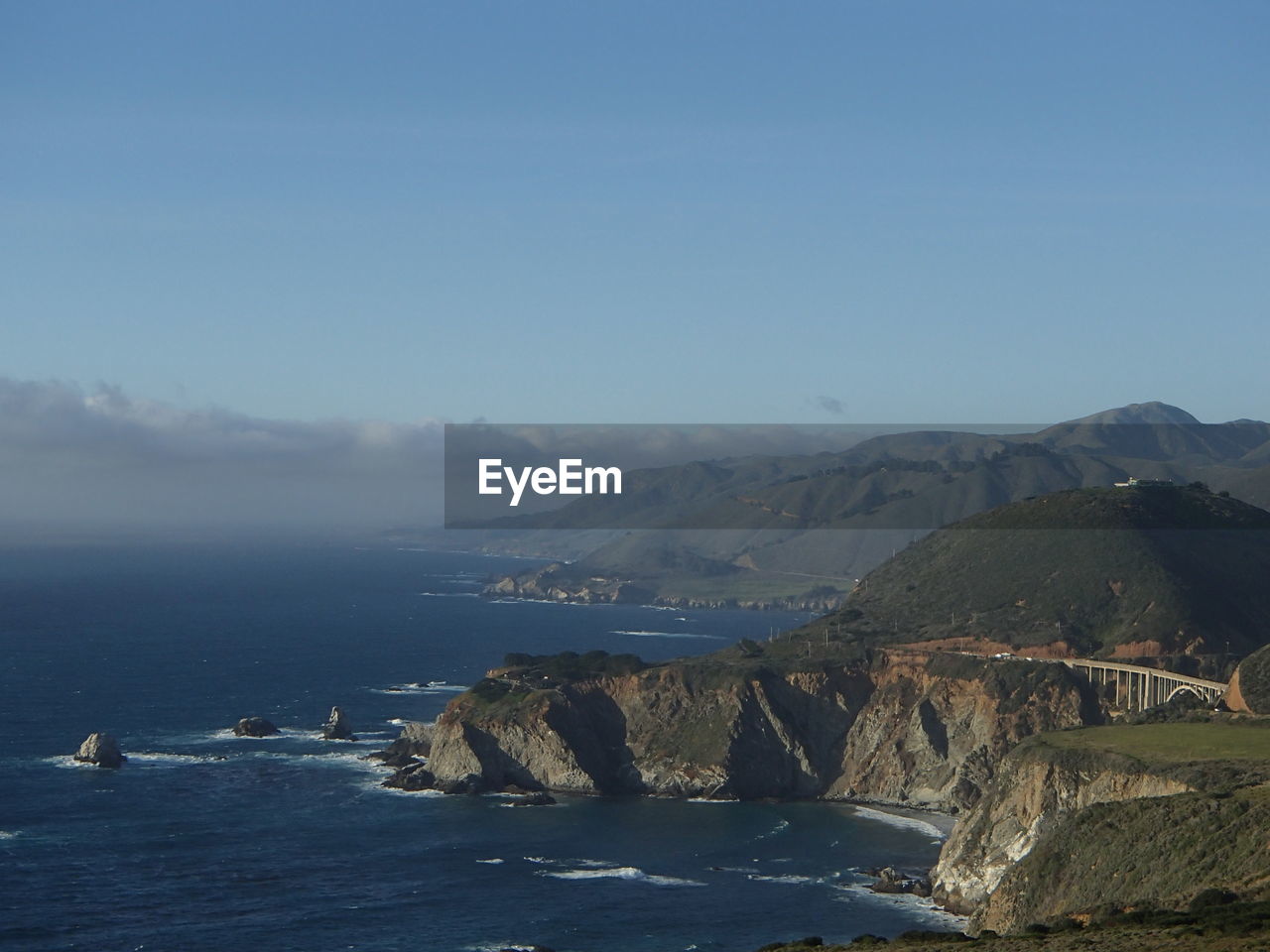 SCENIC VIEW OF SEA BY MOUNTAIN AGAINST SKY