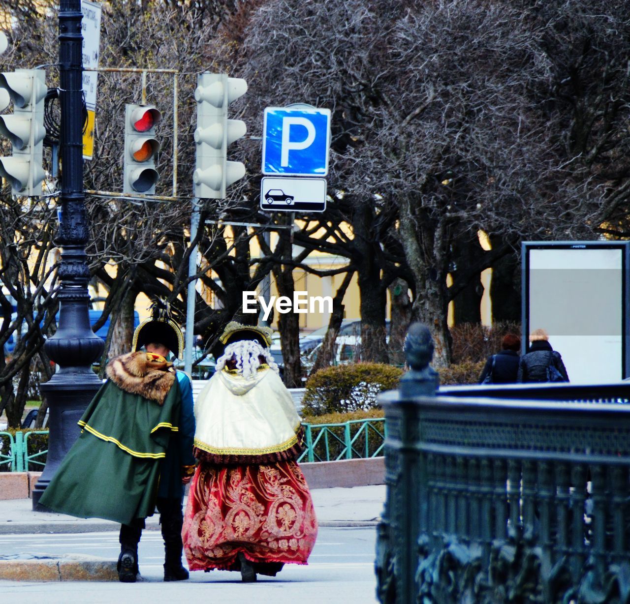 PEOPLE WALKING IN FRONT OF TREES