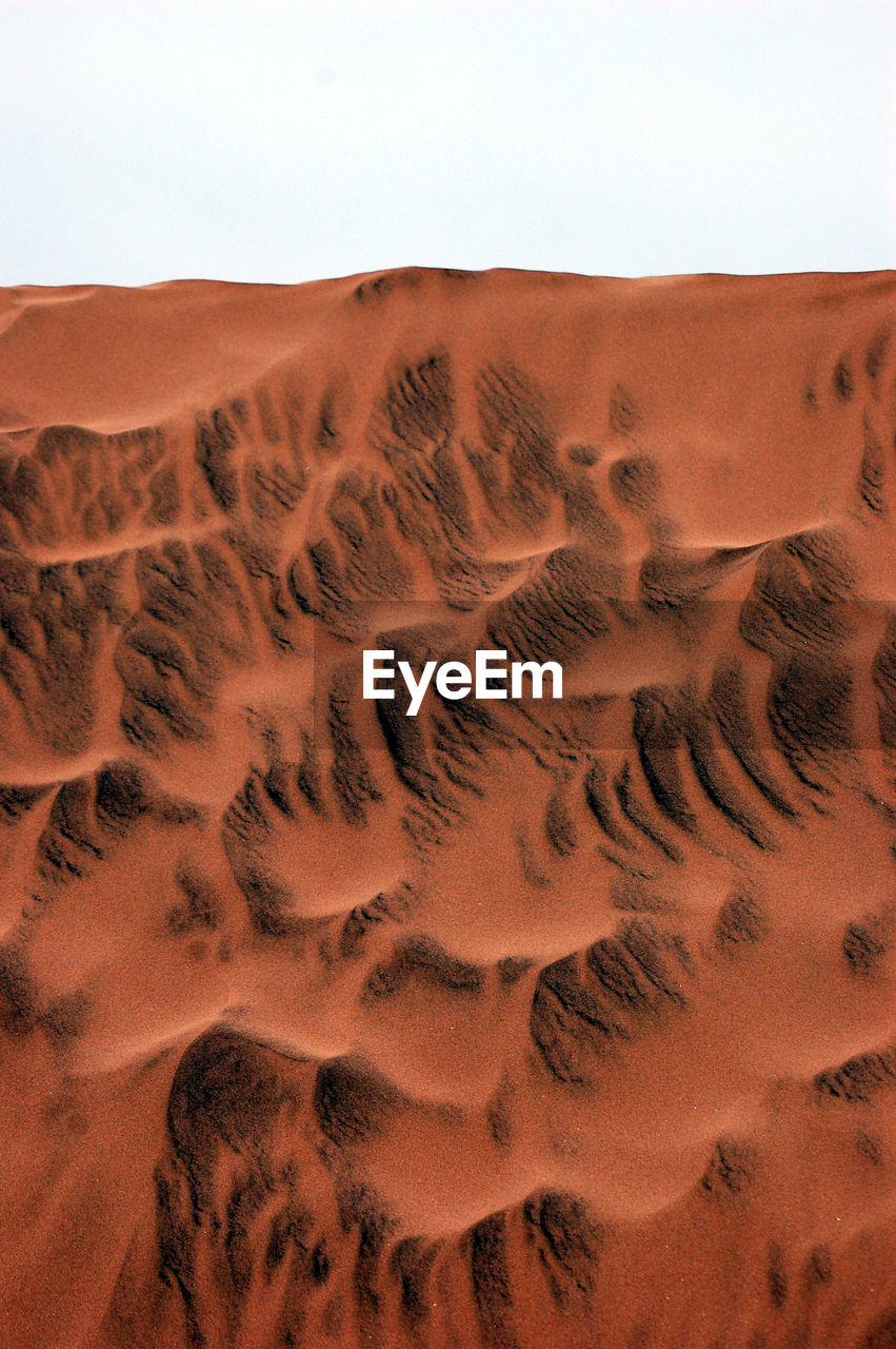 Sand dune in desert against clear sky