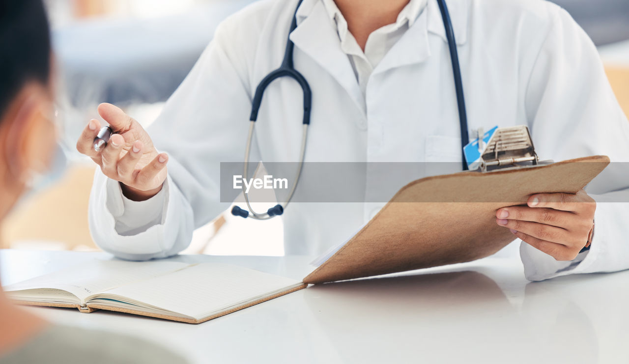 midsection of doctor examining patient at clinic