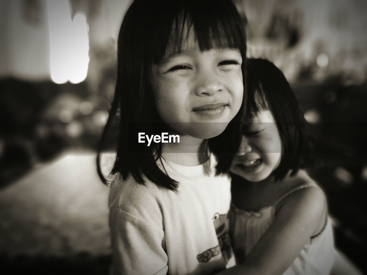 Portrait of cute girl embracing sister at home