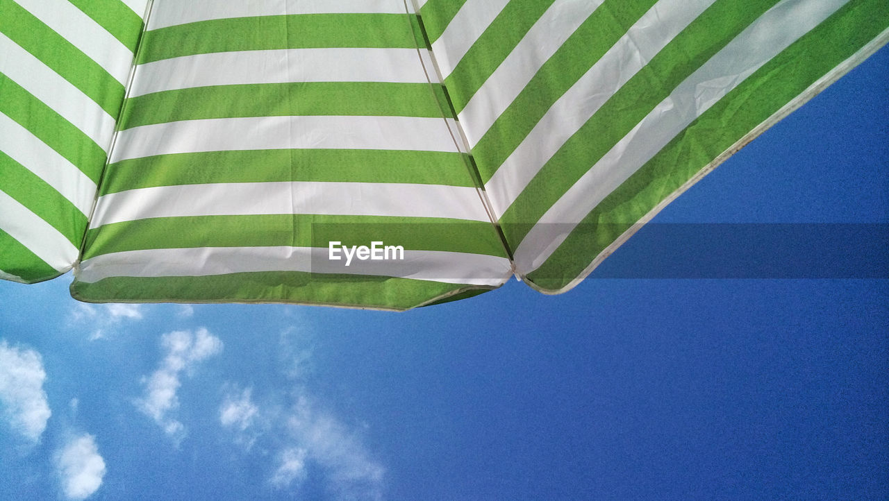 LOW ANGLE VIEW OF UMBRELLA AGAINST BLUE SKY AND CLOUDS