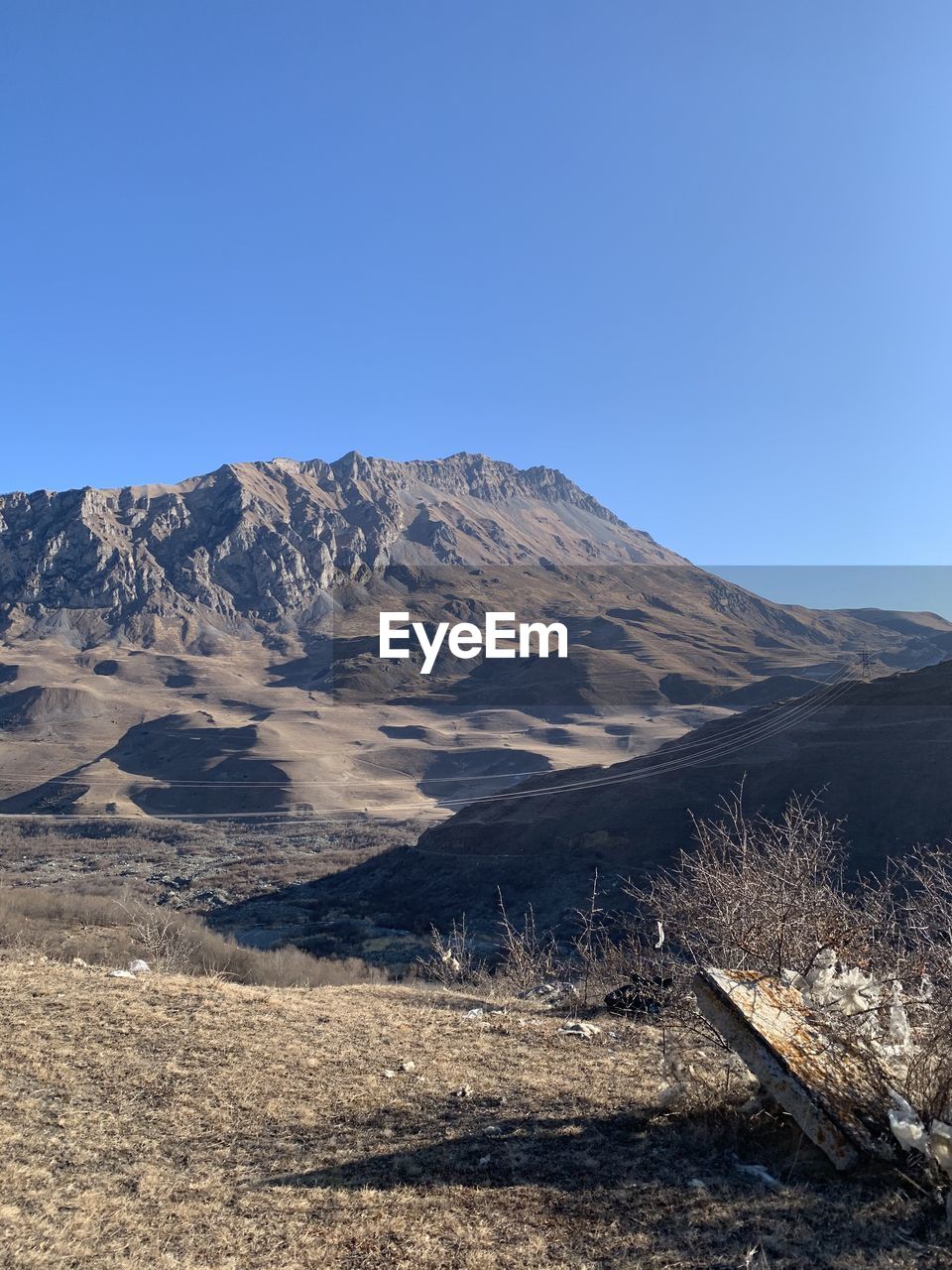 SCENIC VIEW OF LAND AND MOUNTAINS AGAINST CLEAR BLUE SKY